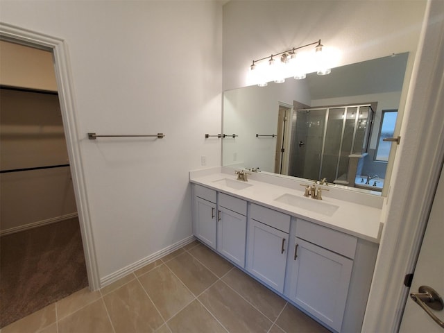 bathroom with an enclosed shower, vanity, and tile patterned flooring