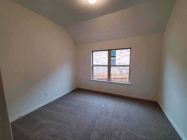 carpeted empty room featuring lofted ceiling