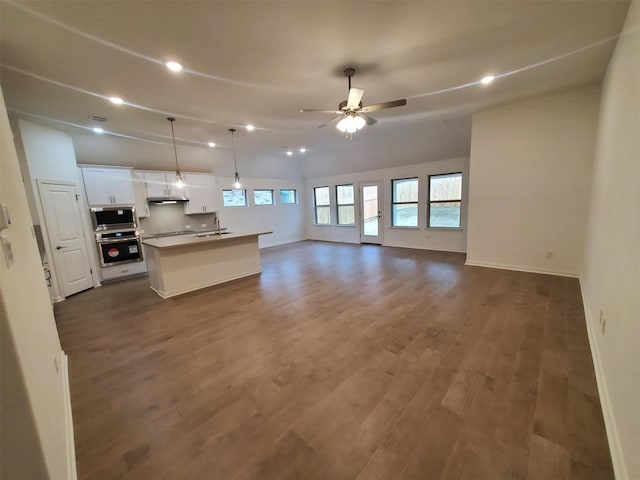 kitchen with hanging light fixtures, an island with sink, ceiling fan, stainless steel appliances, and white cabinets