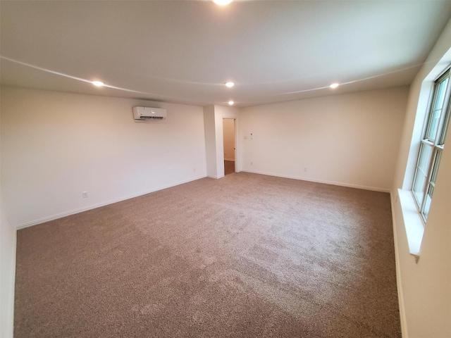 unfurnished room with a wall mounted air conditioner, a wealth of natural light, and carpet floors