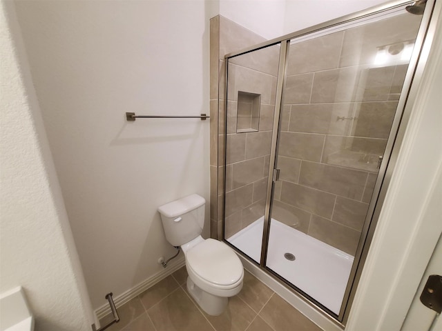 bathroom with toilet, tile patterned floors, and a shower with shower door