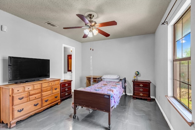 bedroom featuring a textured ceiling, ceiling fan, and ensuite bathroom