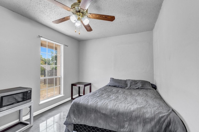 bedroom featuring ceiling fan, a textured ceiling, and multiple windows