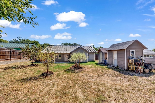 rear view of property with a lawn and an outbuilding