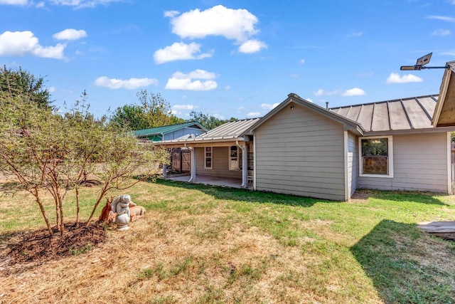 rear view of house with a lawn and a patio area