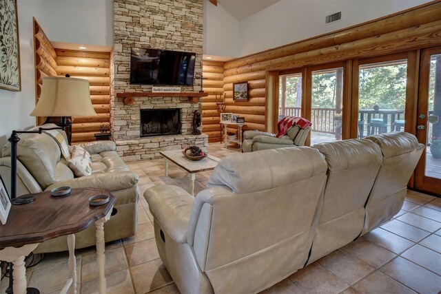 tiled living room featuring high vaulted ceiling, rustic walls, french doors, and a stone fireplace