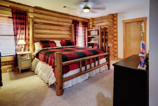 bedroom featuring ceiling fan, carpet, and log walls