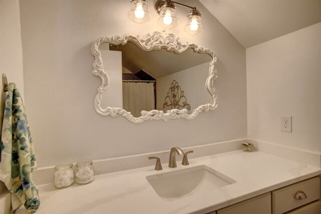 bathroom with vanity and lofted ceiling