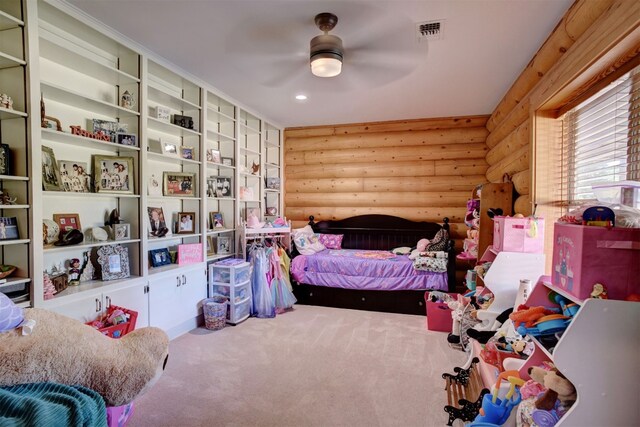 bedroom with ceiling fan, log walls, and carpet flooring