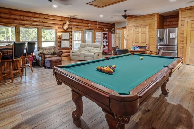 game room with pool table, light hardwood / wood-style floors, log walls, and ceiling fan