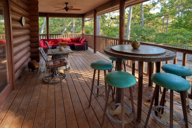 wooden deck featuring an outdoor living space and ceiling fan