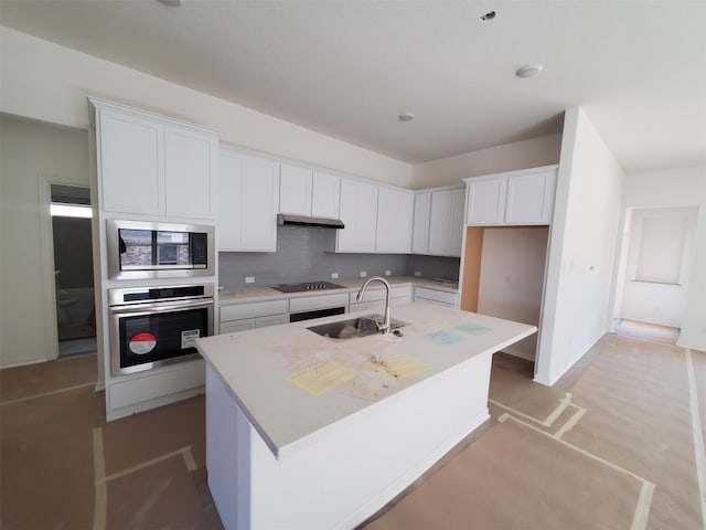 kitchen featuring sink, a center island with sink, white cabinetry, and stainless steel oven