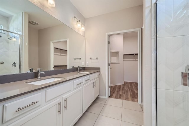 bathroom featuring vanity, tile patterned floors, and a shower with door