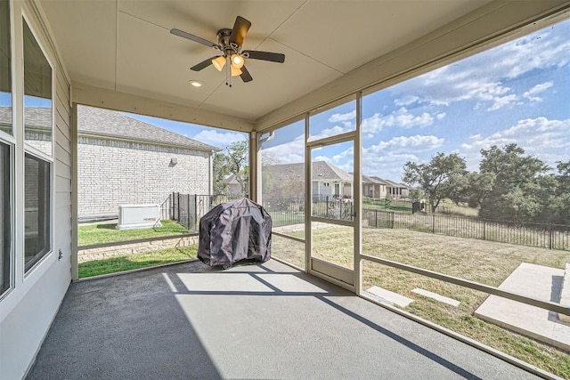 unfurnished sunroom featuring ceiling fan