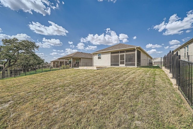 back of house featuring a sunroom and a lawn