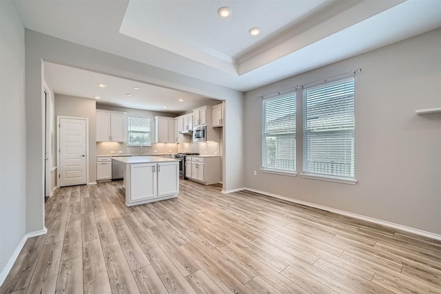 kitchen featuring a center island, light hardwood / wood-style floors, stainless steel appliances, and a wealth of natural light