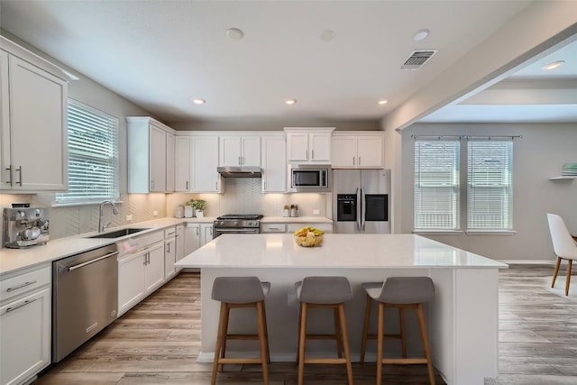 kitchen with white cabinets, sink, a kitchen island, and stainless steel appliances