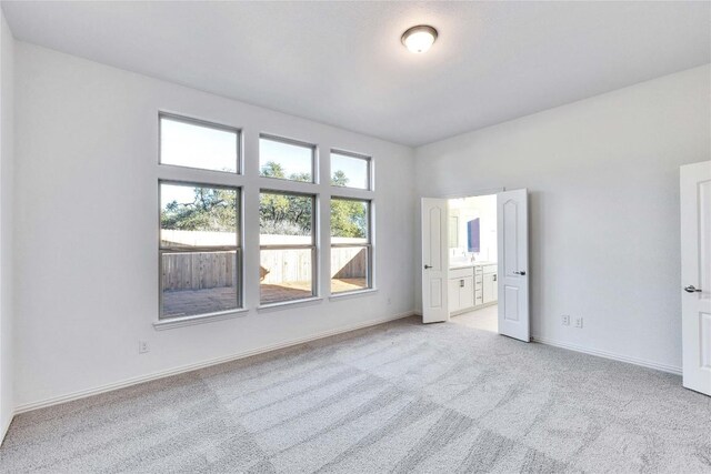 1429 Cole Estates Dr, Georgetown, TX 78628 - unfurnished bedroom featuring light carpet, baseboards, and ensuite bath