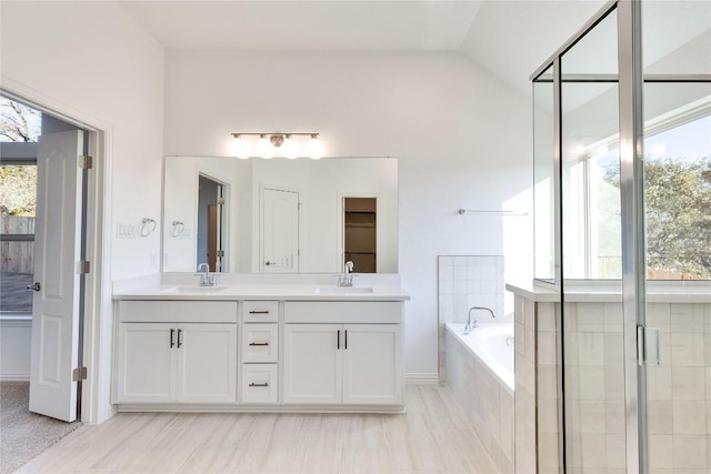 bathroom featuring lofted ceiling, shower with separate bathtub, and vanity