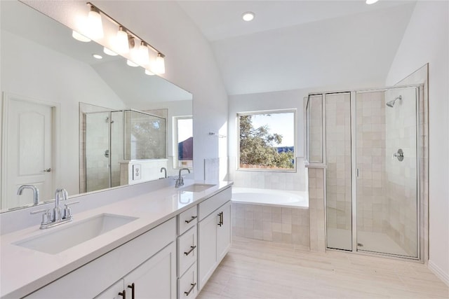 bathroom featuring vaulted ceiling, shower with separate bathtub, and vanity