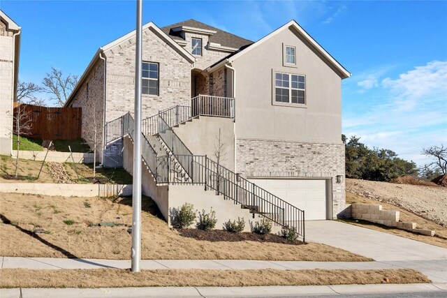 1429 Cole Estates Dr, Georgetown, TX 78628 - view of front of property featuring brick siding, stairs, driveway, an attached garage, and stucco siding