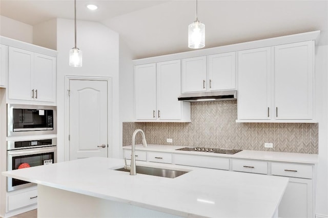 kitchen featuring sink, white cabinets, built in microwave, decorative light fixtures, and stainless steel oven