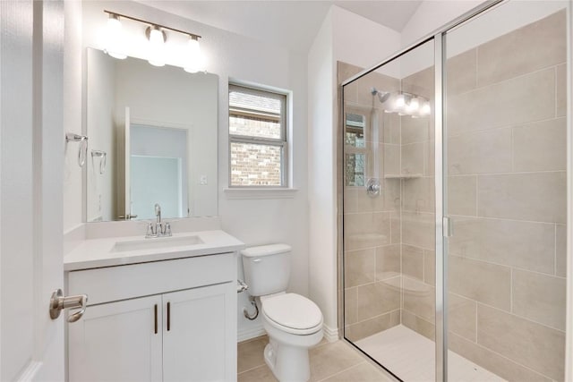 bathroom with a shower with door, vanity, tile patterned floors, and toilet