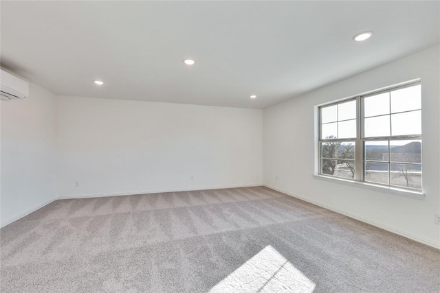 empty room featuring a wall mounted AC and light colored carpet