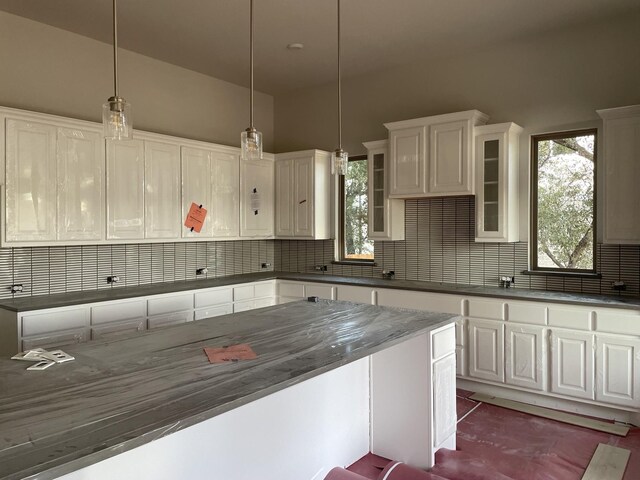 kitchen featuring white cabinets, pendant lighting, and decorative backsplash