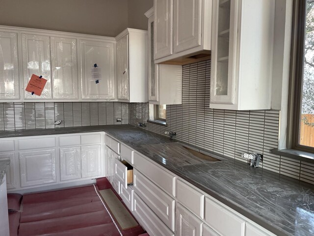 kitchen with backsplash, a wealth of natural light, and white cabinets