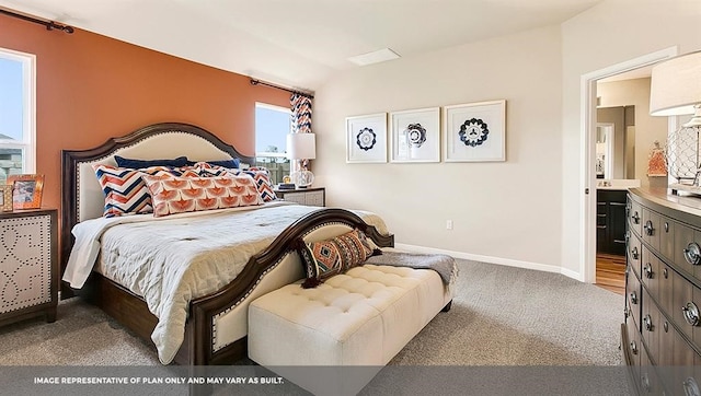 carpeted bedroom with vaulted ceiling and ensuite bath