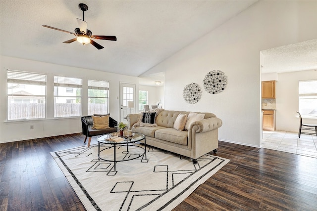 living room with a textured ceiling, ceiling fan, plenty of natural light, and dark hardwood / wood-style flooring