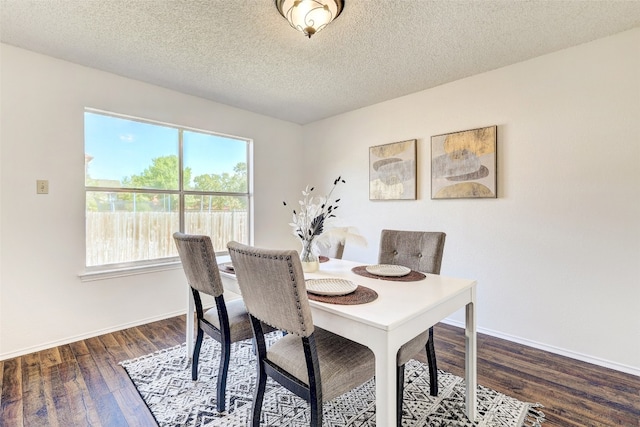 dining space featuring a textured ceiling and dark hardwood / wood-style floors