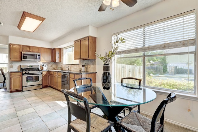 kitchen with ceiling fan, light tile patterned flooring, sink, tasteful backsplash, and stainless steel appliances