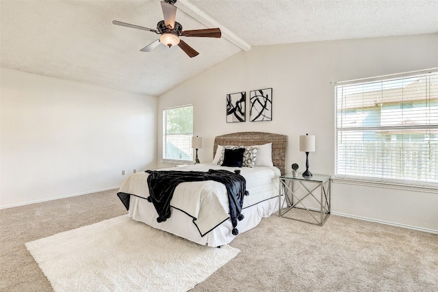 bedroom with a textured ceiling, carpet, lofted ceiling with beams, and ceiling fan