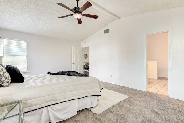 bedroom featuring lofted ceiling with beams, ceiling fan, light colored carpet, and a textured ceiling