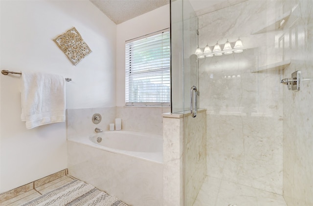 bathroom featuring shower with separate bathtub and a textured ceiling