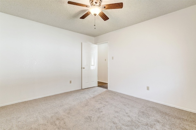 carpeted empty room featuring ceiling fan and a textured ceiling