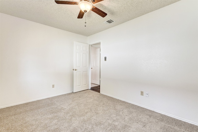 carpeted spare room featuring a textured ceiling and ceiling fan