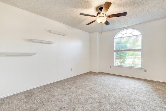 spare room with a textured ceiling, carpet flooring, and ceiling fan