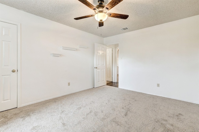 carpeted spare room with ceiling fan and a textured ceiling