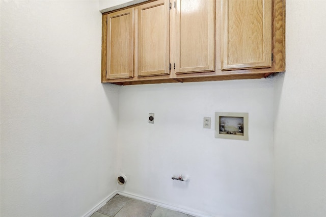 washroom with washer hookup, light tile patterned floors, gas dryer hookup, cabinets, and electric dryer hookup