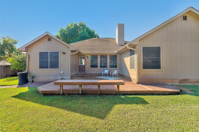 rear view of house with a deck and a yard