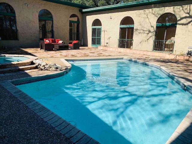 view of swimming pool featuring a patio, an outdoor living space, and an in ground hot tub