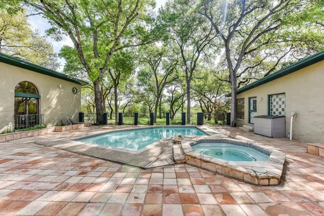 view of swimming pool featuring an in ground hot tub and a patio area