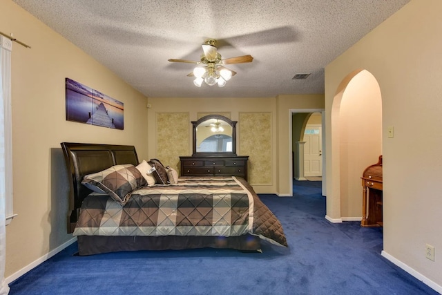 carpeted bedroom with ceiling fan and a textured ceiling