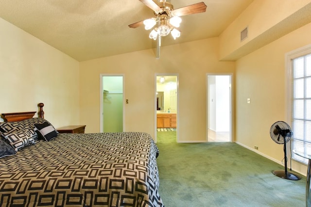 carpeted bedroom with vaulted ceiling, a spacious closet, connected bathroom, a closet, and ceiling fan