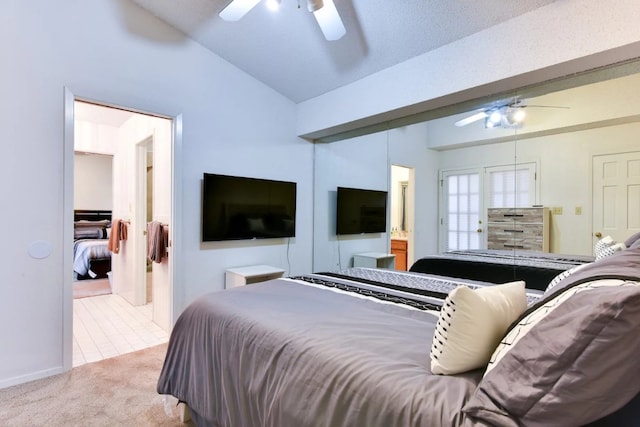 bedroom featuring ceiling fan, light colored carpet, lofted ceiling, and ensuite bathroom