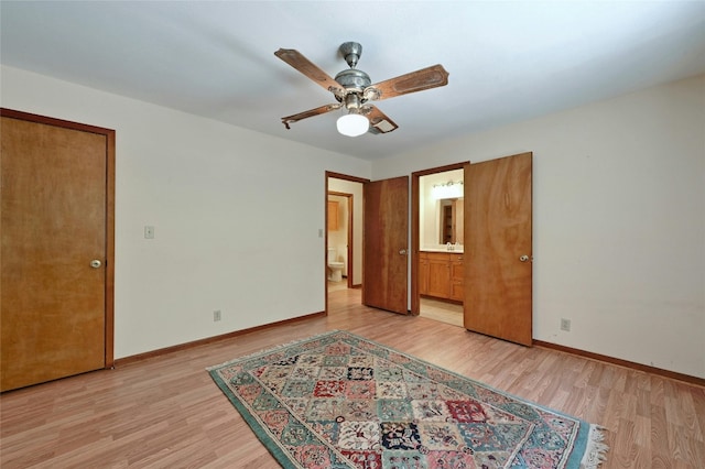 unfurnished bedroom featuring ceiling fan, ensuite bathroom, and light hardwood / wood-style floors