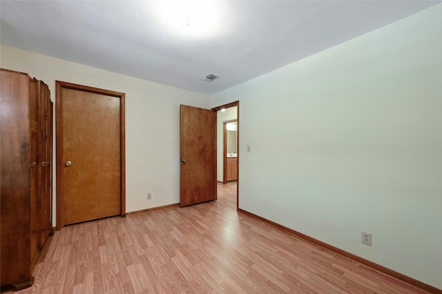 unfurnished bedroom featuring light hardwood / wood-style flooring and a closet